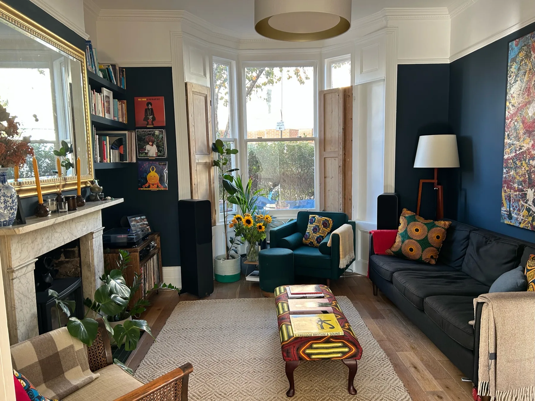 Una sala de estar con asientos oscuros, una chimenea y grandes ventanas.
