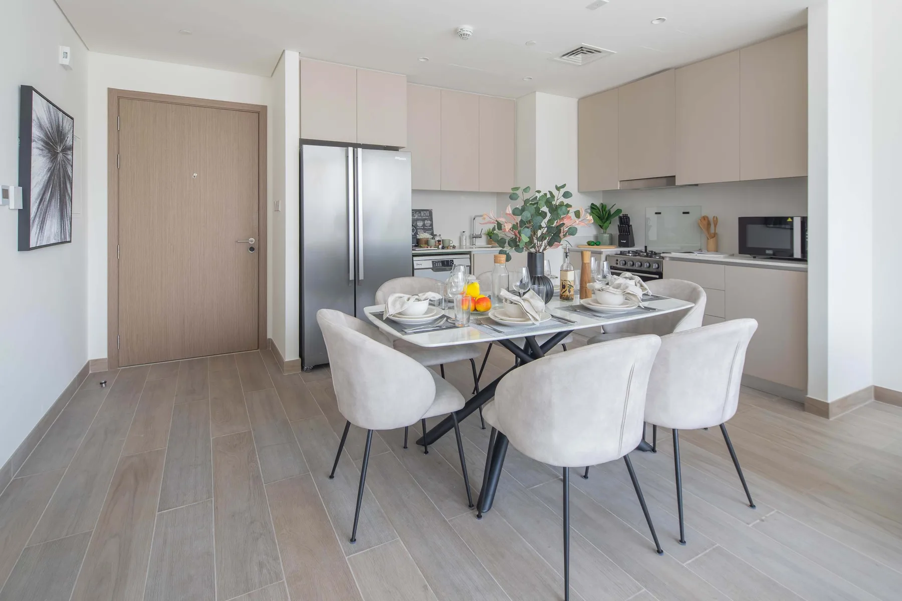 Un comedor con la mesa puesta está junto a una cocina abierta.