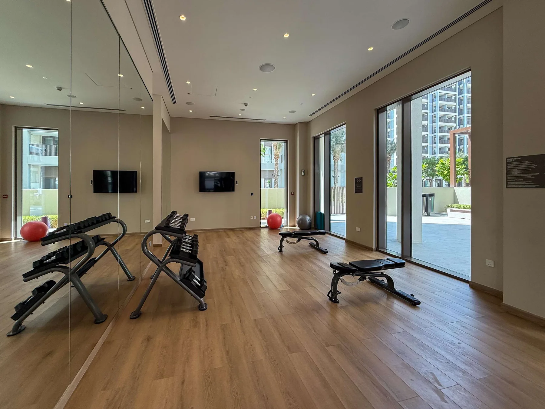Una sala de ejercicio con equipos de entrenamiento y grandes ventanas.