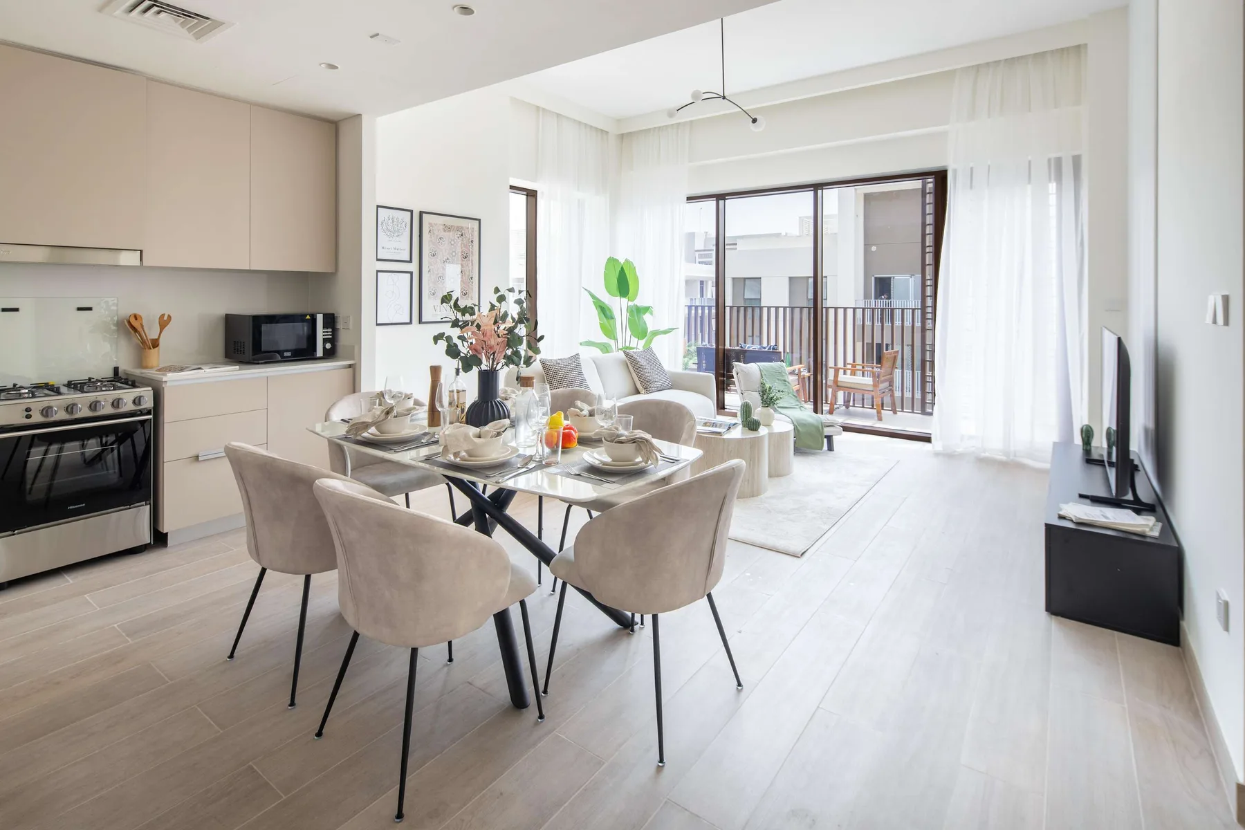 Una luminosa sala de estar y comedor diáfana, con grandes ventanas y muebles en tonos neutros.