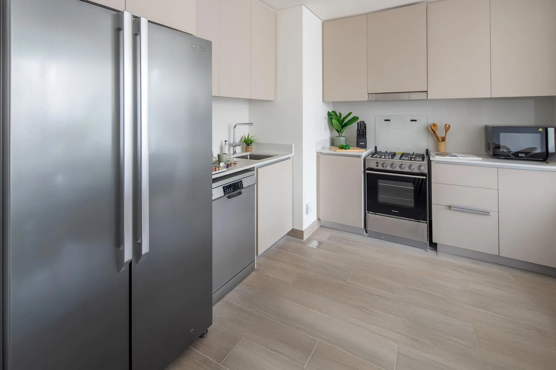 Una cocina moderna con gabinetes claros, electrodomésticos de acero inoxidable y una cocina central.