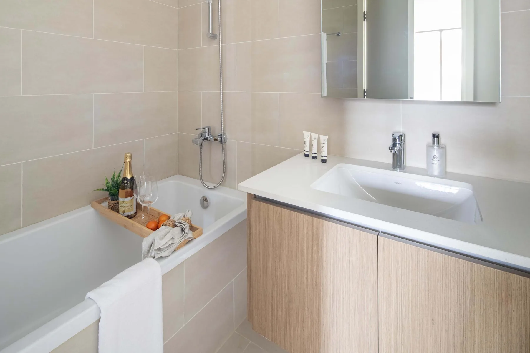 Un baño luminoso con bañera y lavabo con mueble.
