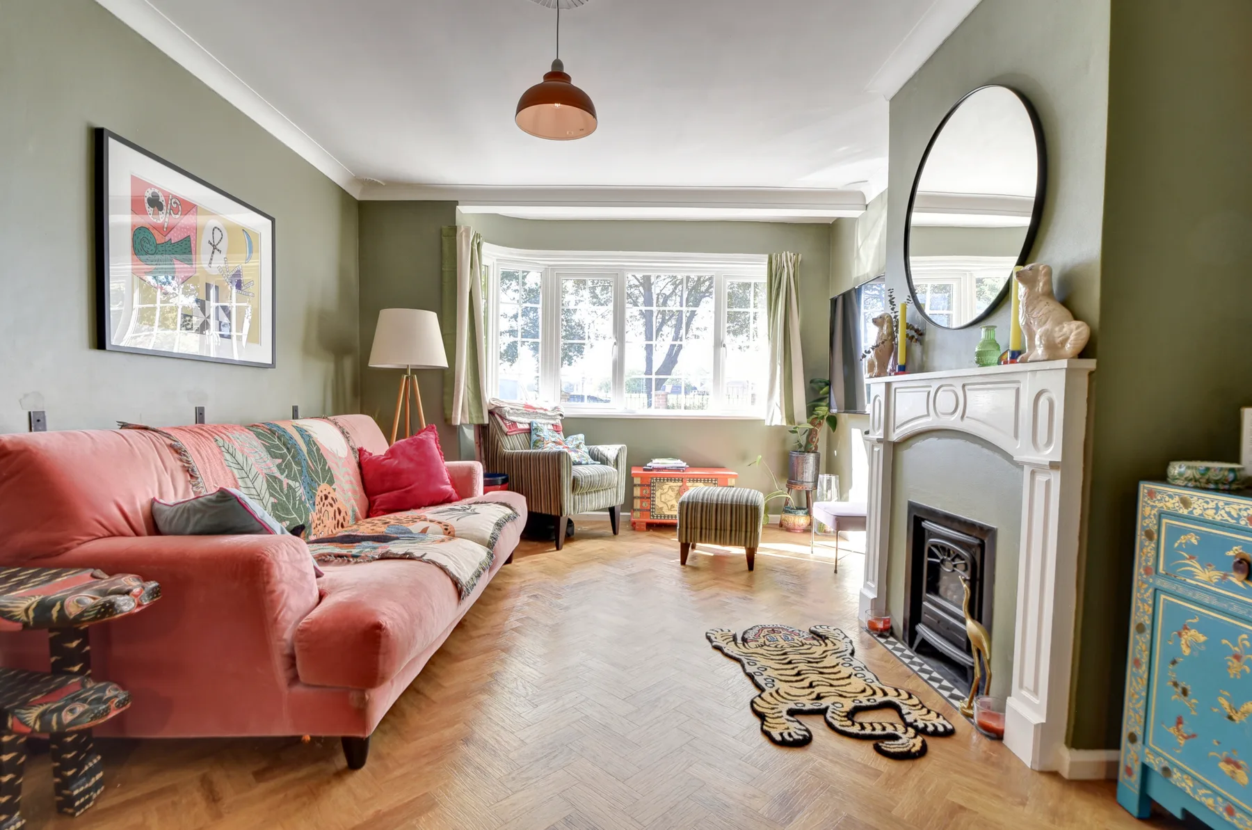 A living room with seating, a fireplace, and a large window.