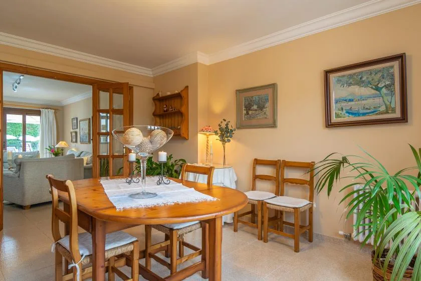 Un comedor con una mesa de madera, sillas y cuadros en las paredes.