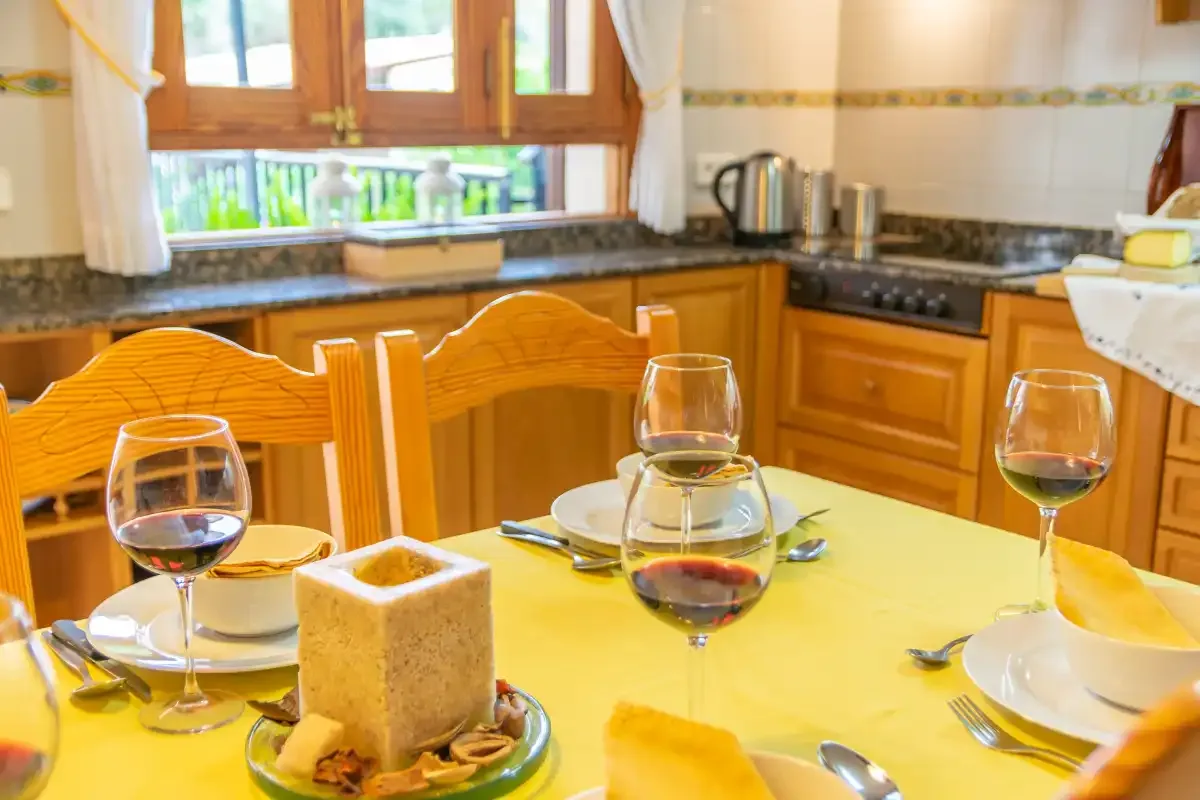 Una cocina y comedor con armarios de madera y una mesa puesta.