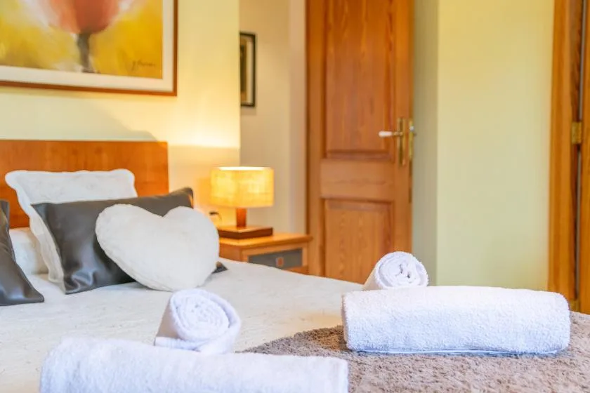 Un dormitorio con una cama tendida y toallas dobladas.