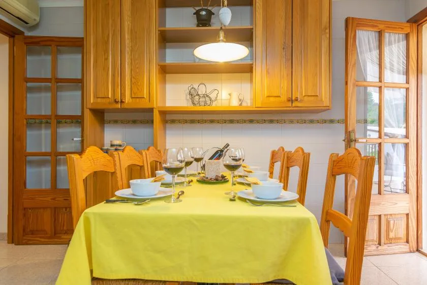 Un comedor con una mesa puesta bajo armarios de madera.