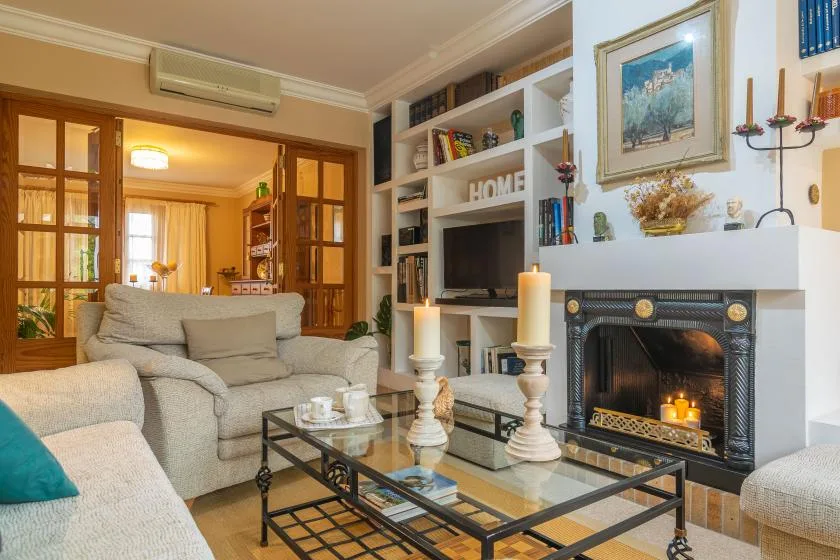 Una sala de estar con asientos, una mesa de centro de cristal y una chimenea.