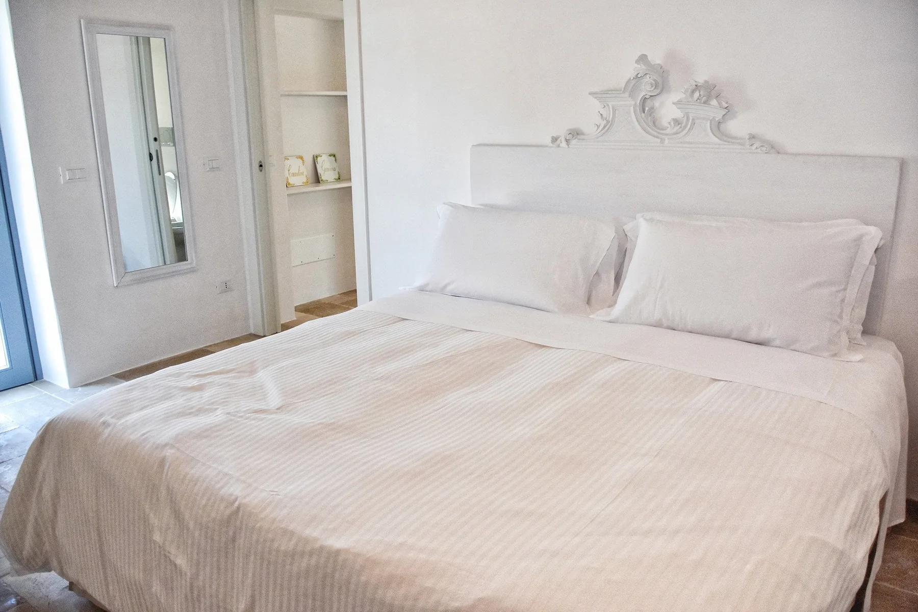 Un dormitorio con una cama tendida y estanterías empotradas.