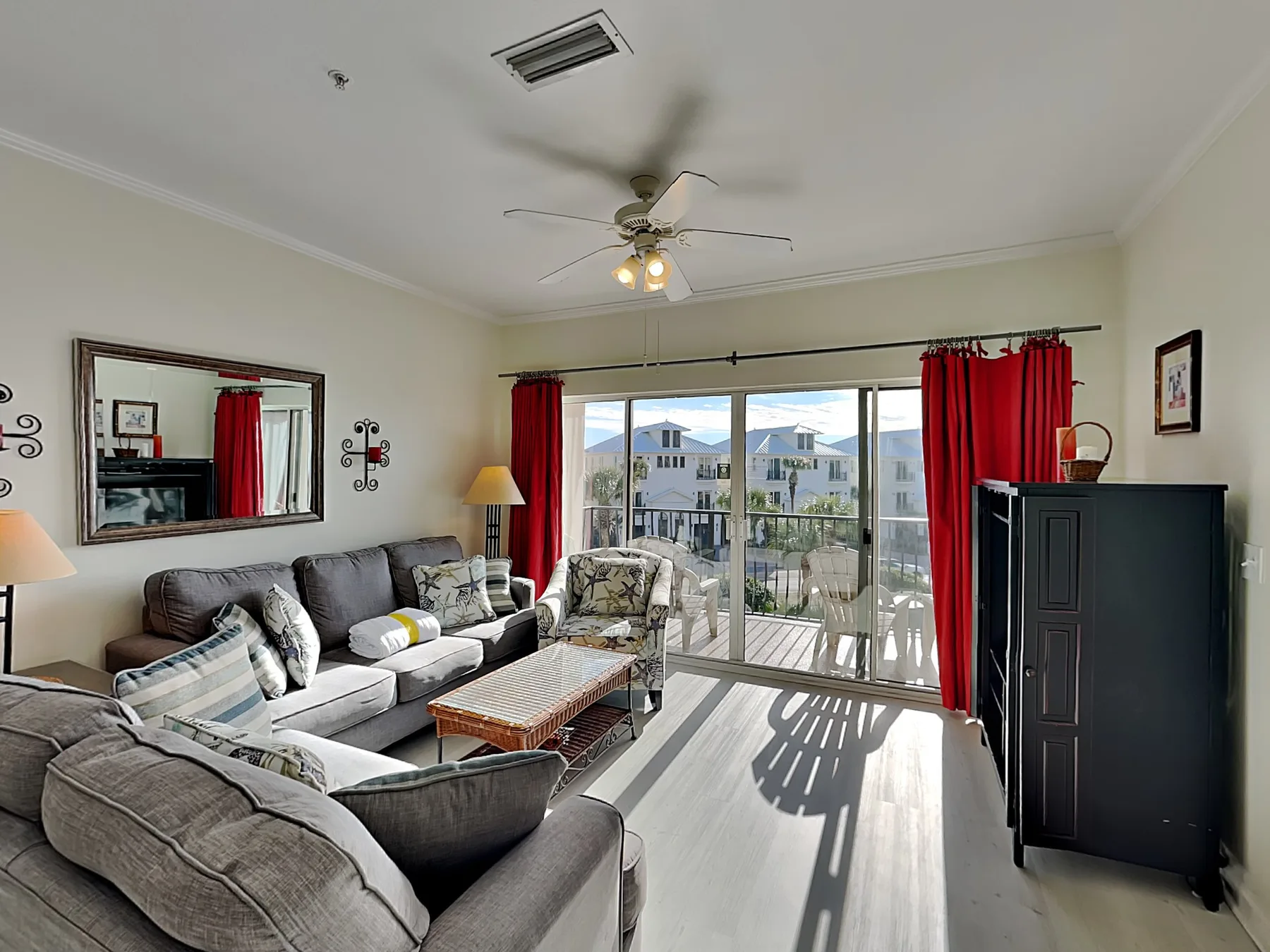 A bright living room has seating arranged around a coffee table beside large glass doors.