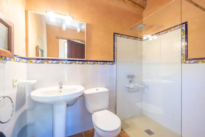 A bathroom with a sink, toilet, and glass shower.