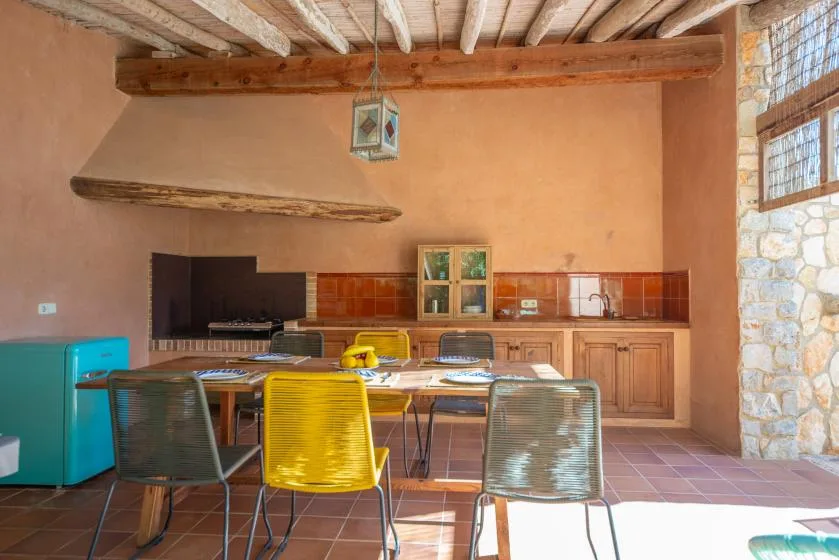 A rustic kitchen and dining area with a long counter and table.