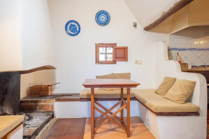 A cozy dining nook with a wooden table and built-in cushioned seating.