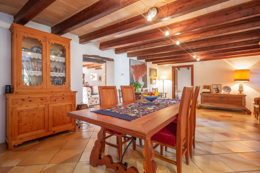 A dining room with a wooden table and a glass-front cabinet.
