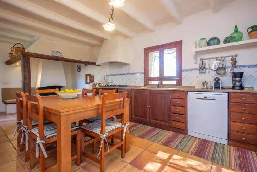A bright kitchen and dining area with a wooden table and cabinetry.
