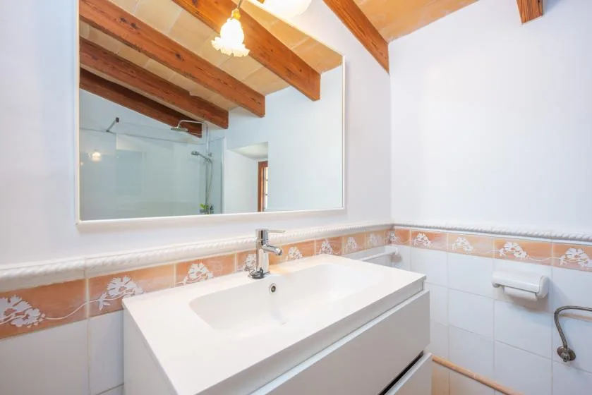 A bright bathroom with a wide sink and a large mirror above it.