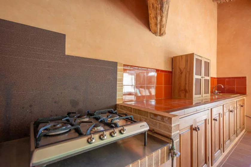 A kitchen with a gas cooktop and wooden cabinets.
