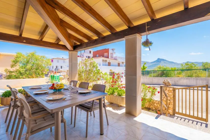 Un comedor exterior cubierto con una mesa y vistas a las montañas.