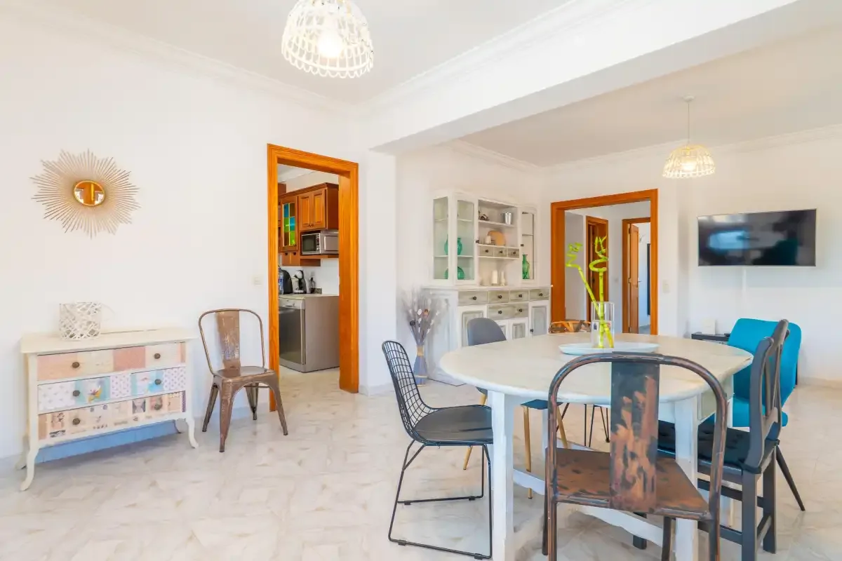 A bright dining room with a white table and blue seating.