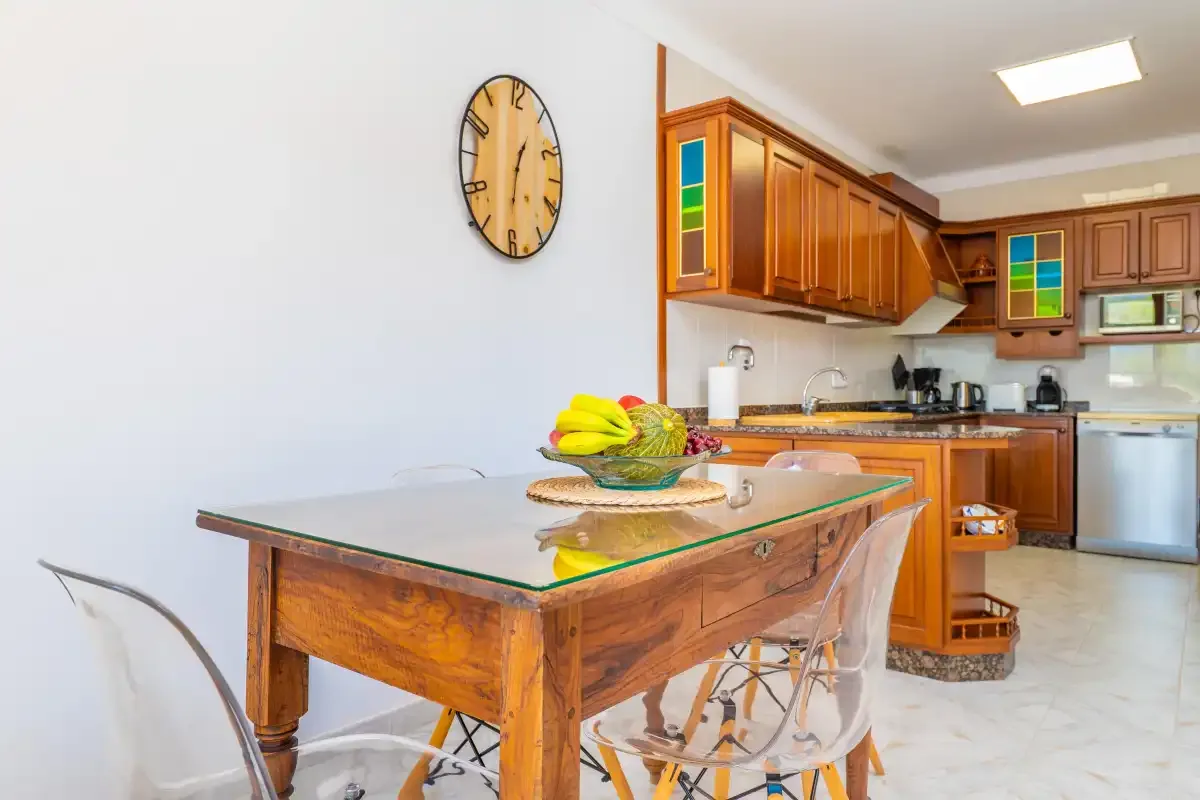 A kitchen and dining area with wooden cabinets and a table.