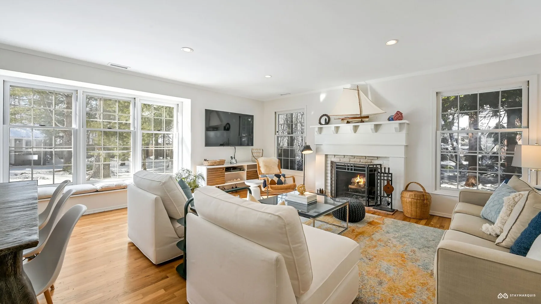 A bright living room with seating arranged around a fireplace and coffee table.