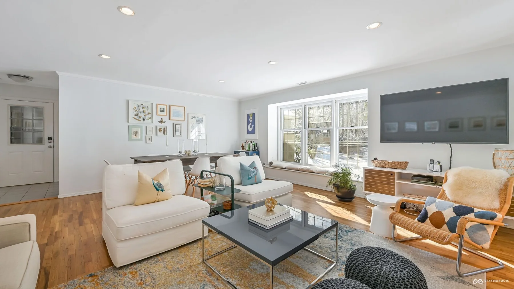 A bright living room with seating around a coffee table and large windows.
