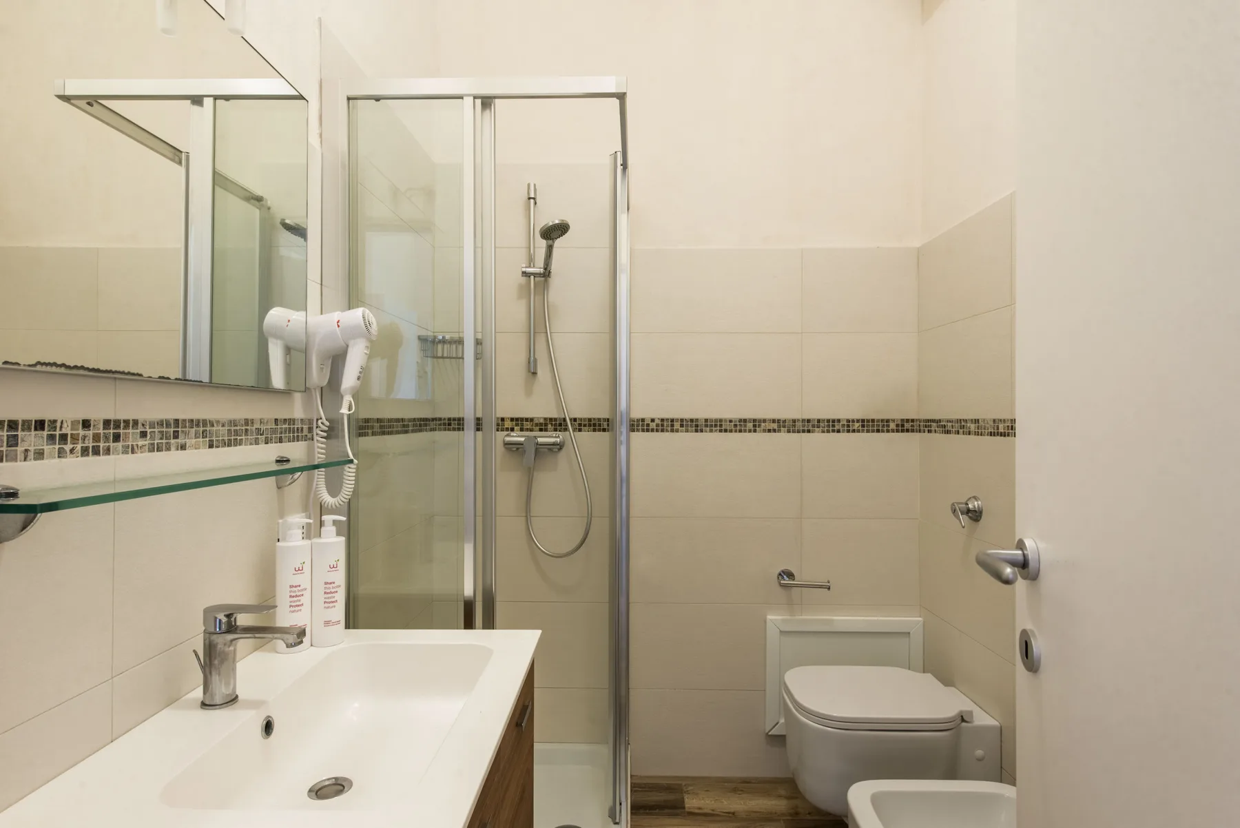 A tiled bathroom with a sink, shower, and toilet.