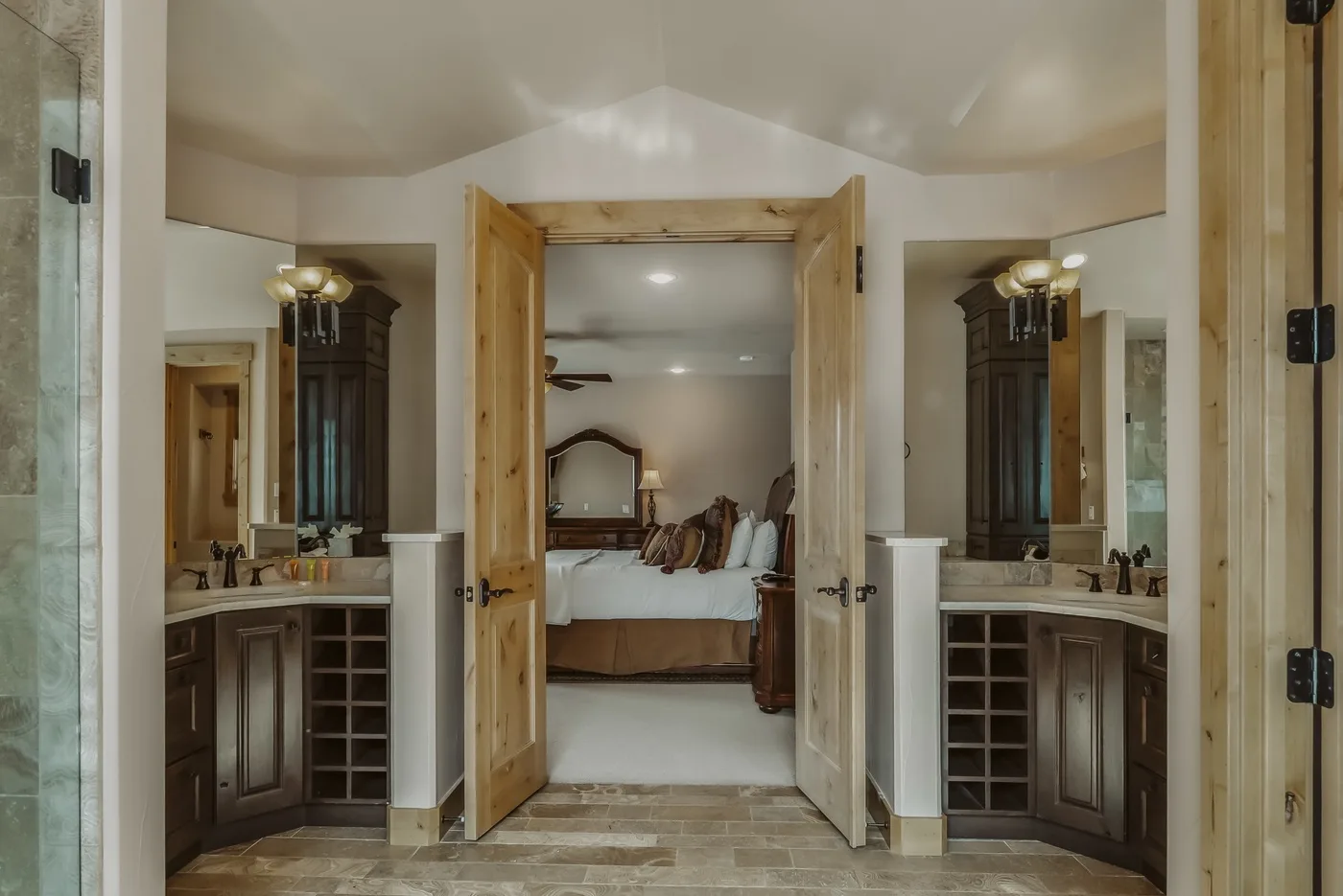 Una puerta abierta muestra un dormitorio entre dos tocadores de baño.