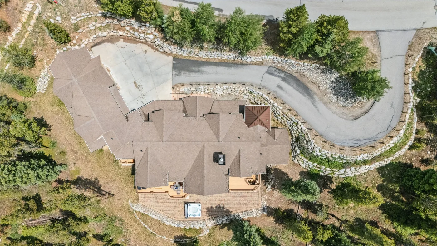 Vista aérea de una casa junto a una entrada curva y jardines.