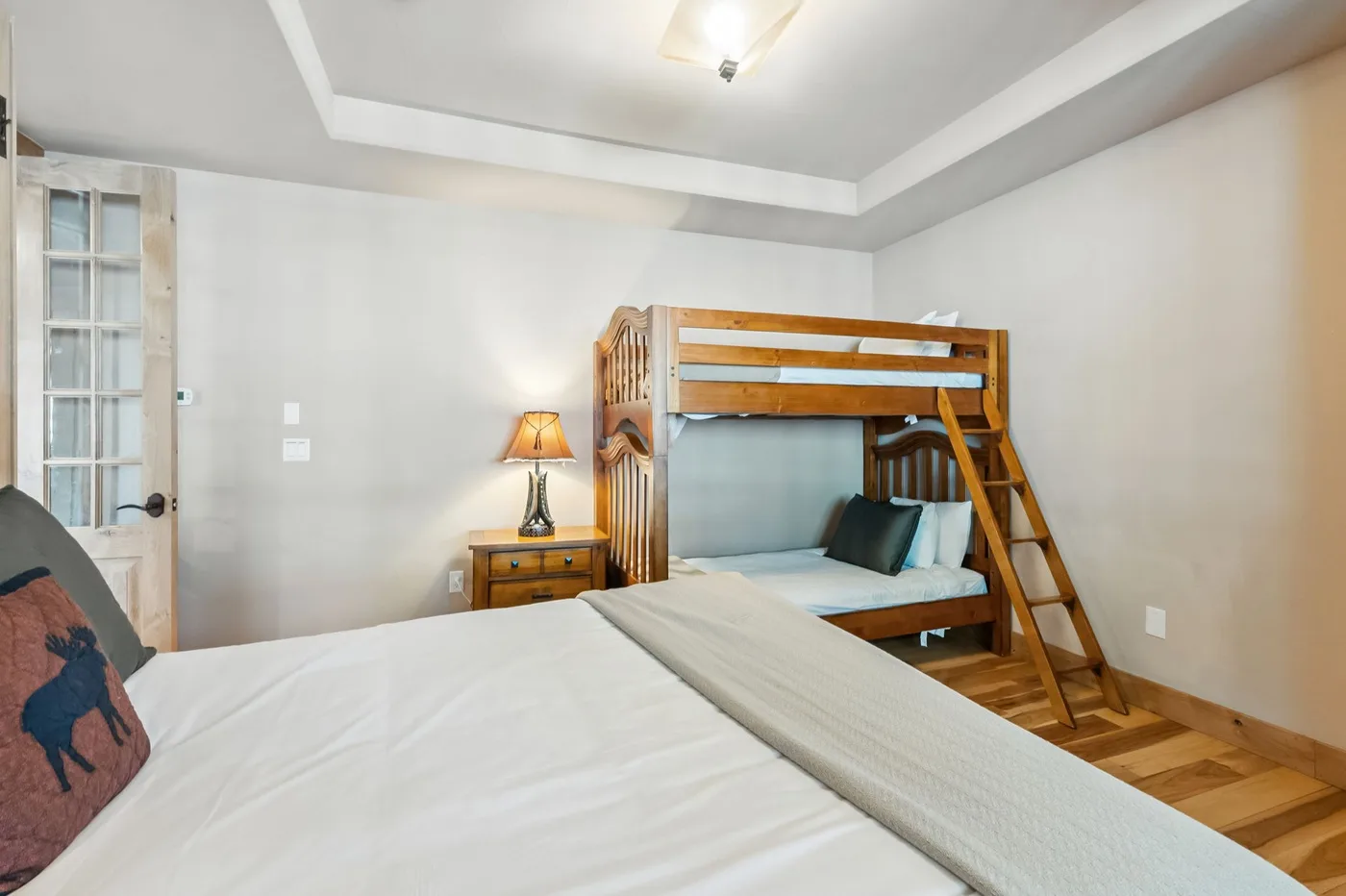Un dormitorio con una litera y una cama en primer plano.
