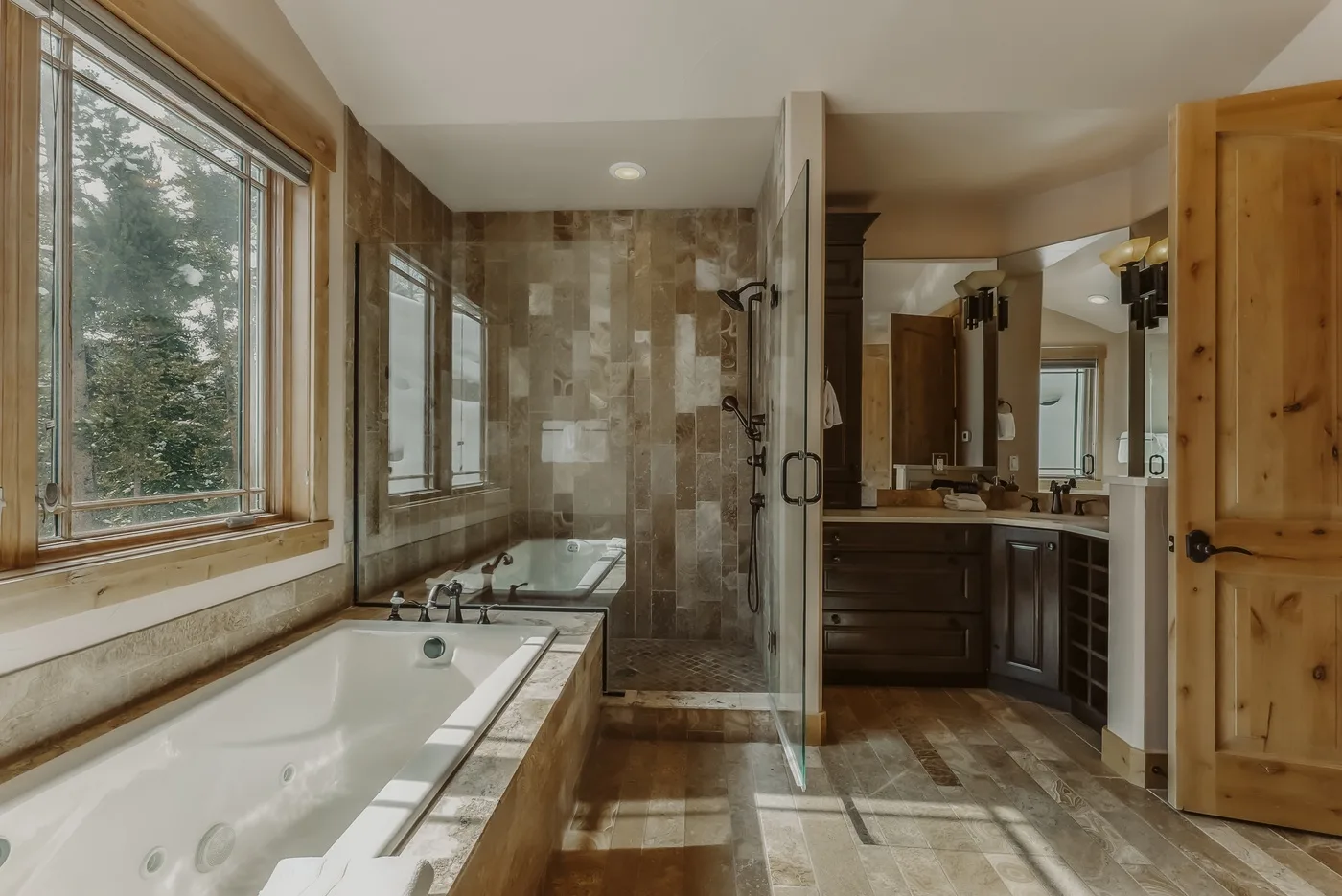 Un baño con bañera, ducha de vidrio y tocador.