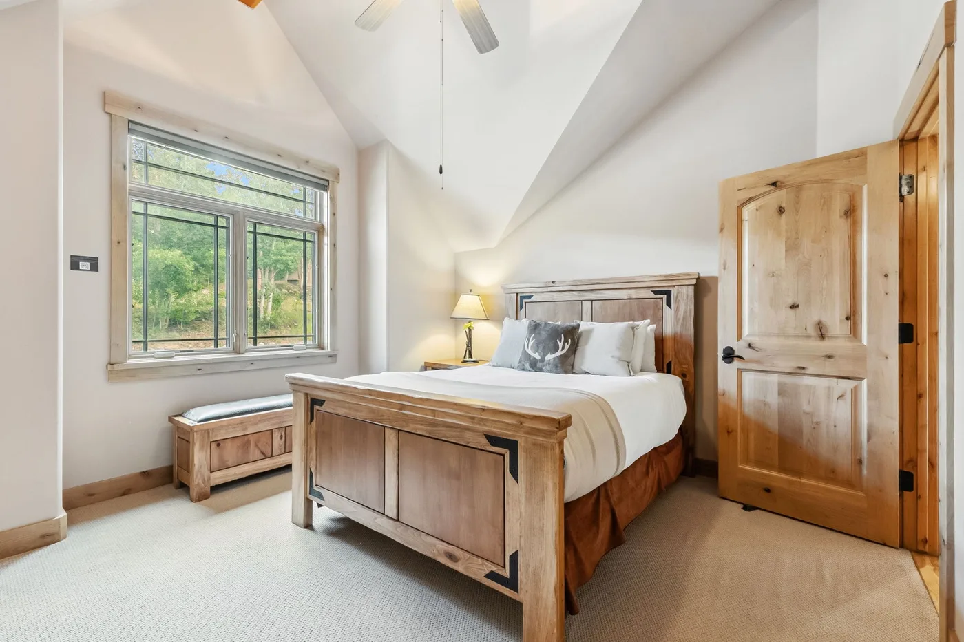 Un dormitorio con una cama de madera y una ventana grande.