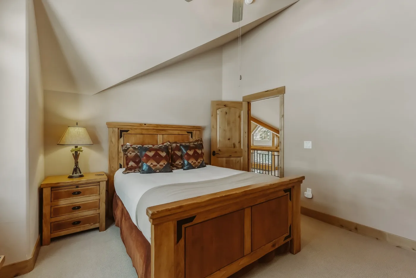 Un dormitorio con una cama de madera y una mesita de noche.