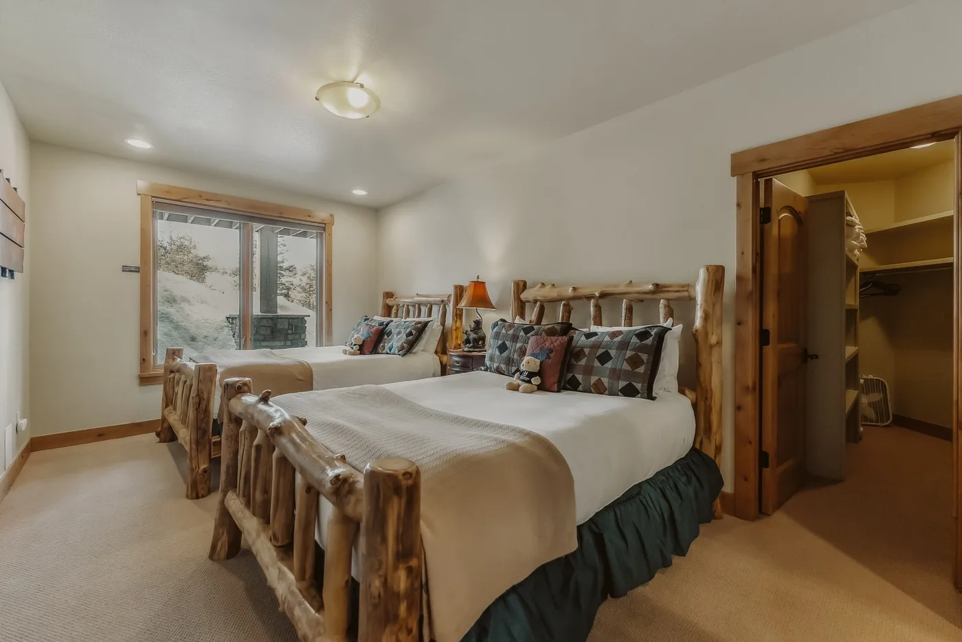 Un dormitorio con una cama grande, cojines estampados y una ventana.