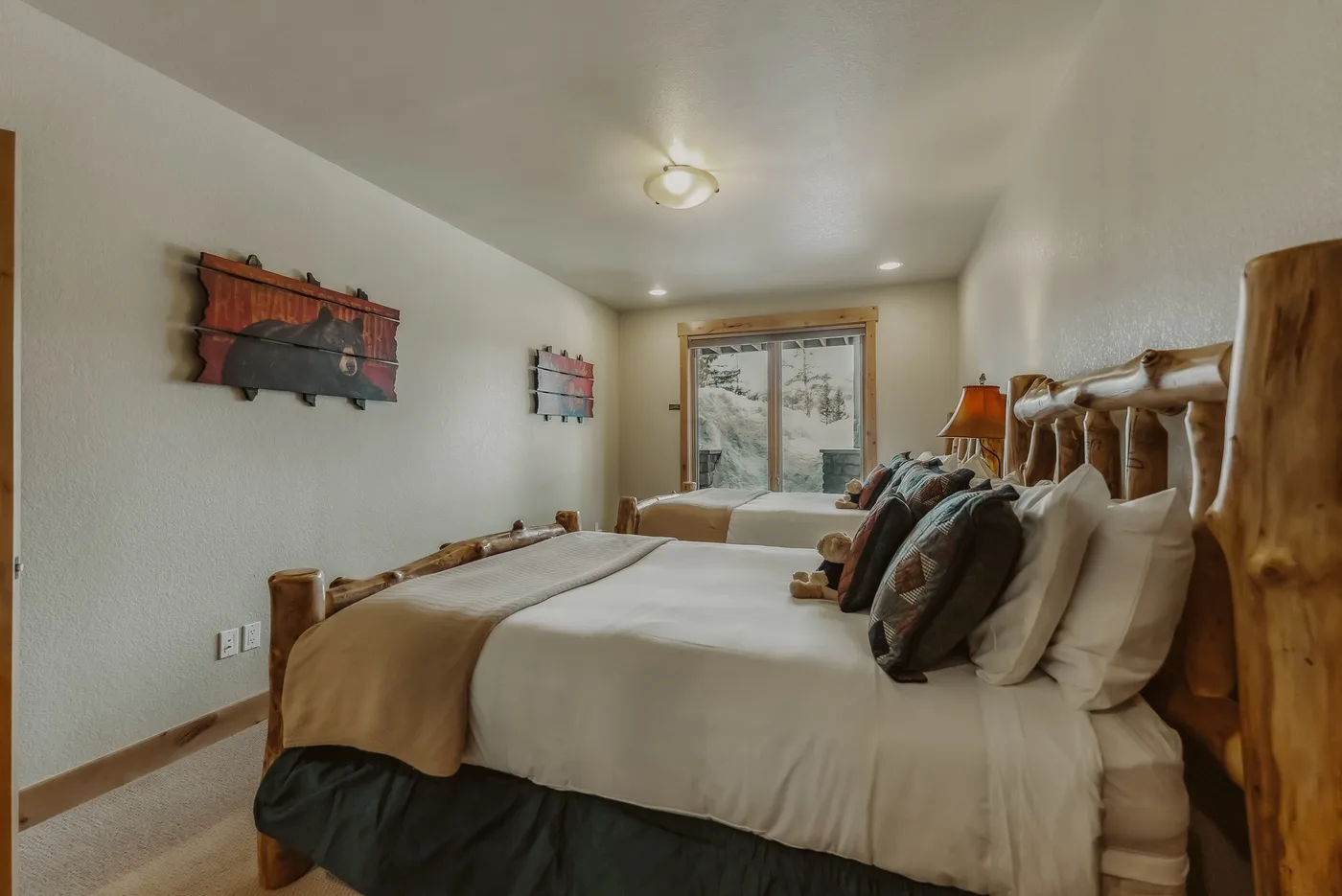 Un dormitorio con una cama grande y puertas corredizas de vidrio con vista a los árboles.