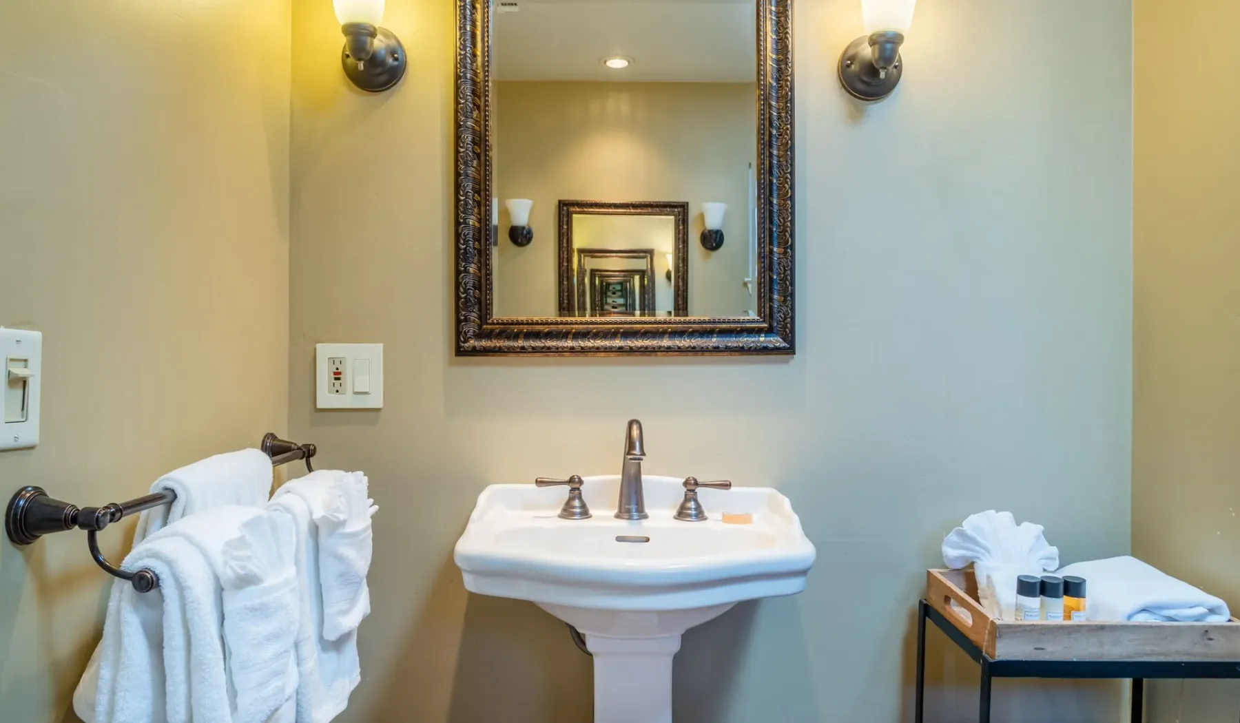 Un lavabo de baño con espejo enmarcado y toallas.