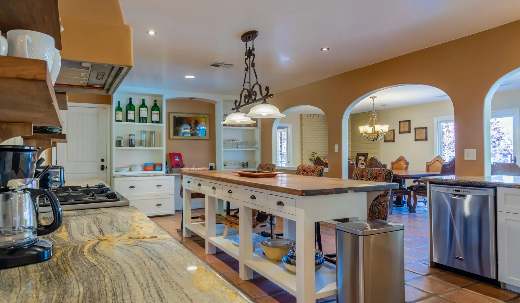 Una cocina amplia con una gran isla central y un comedor al fondo.