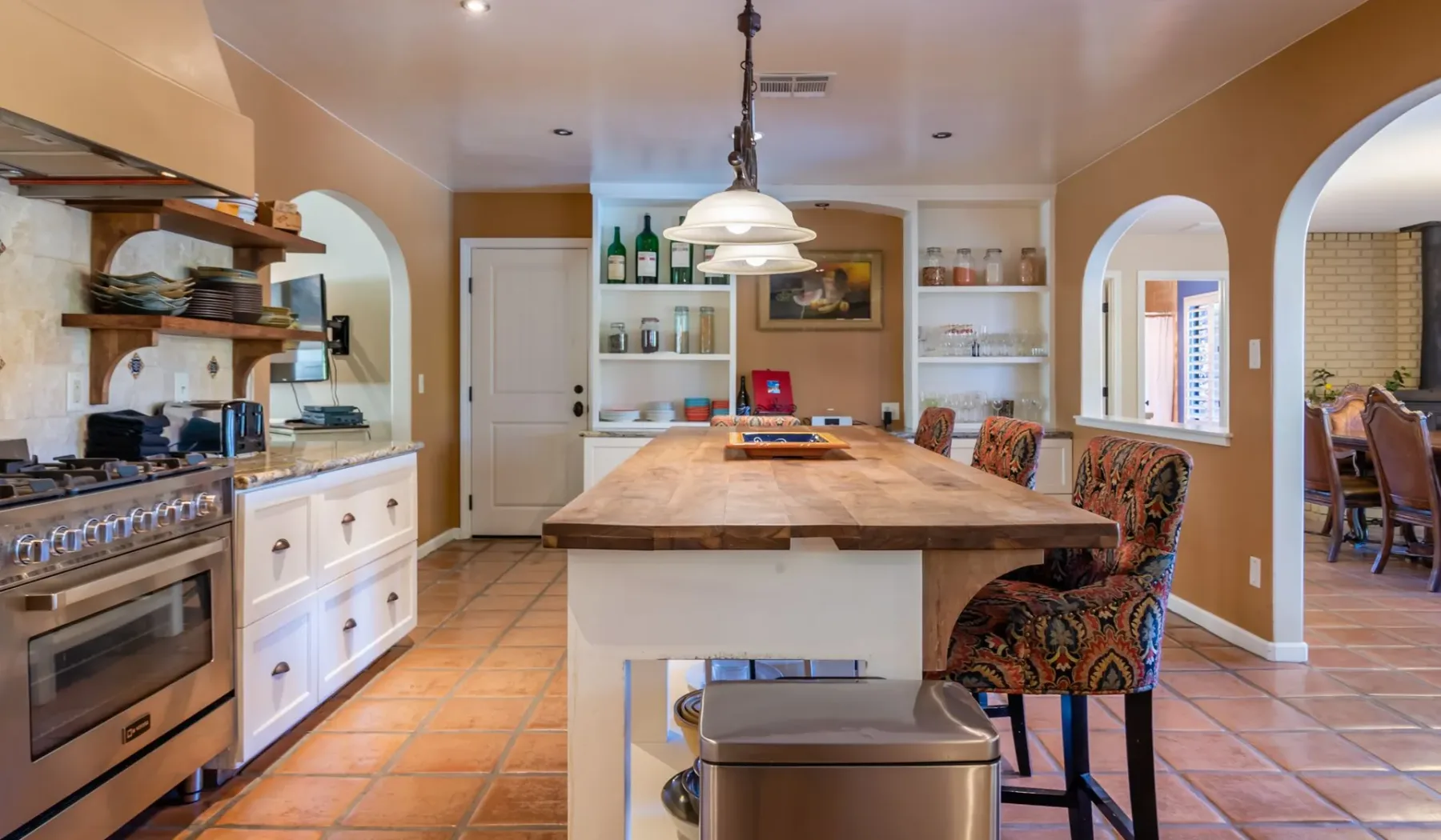 Una cocina con una gran isla central y estantes empotrados.