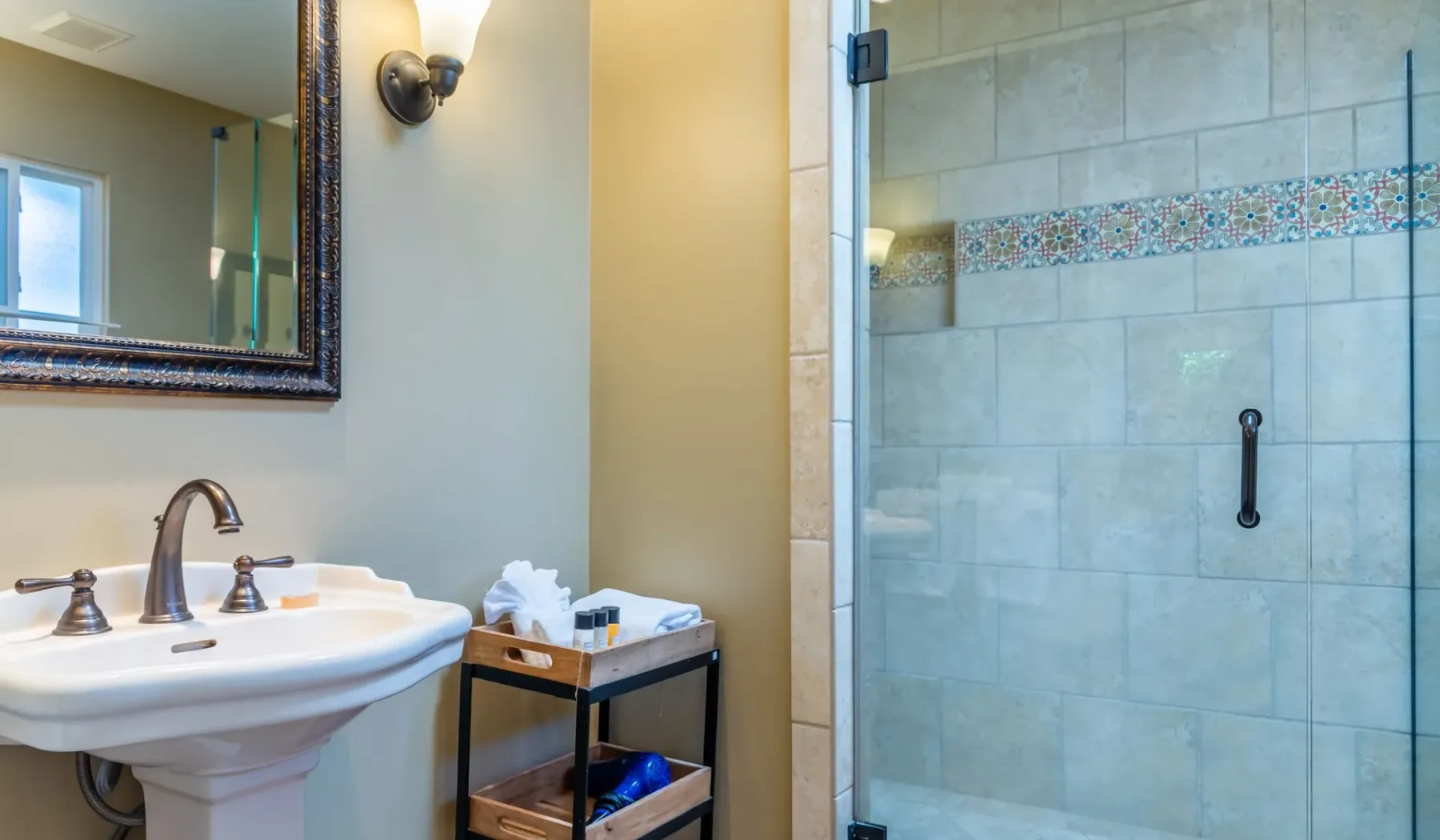 Un baño con un lavabo junto a una ducha de vidrio.
