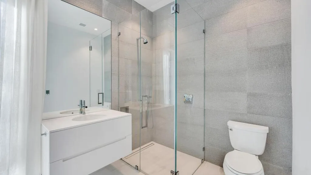 Un baño moderno con lavabo, ducha e inodoro.