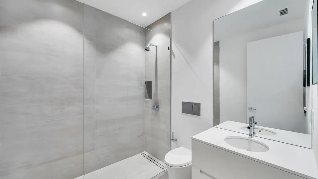 Un baño moderno con ducha, inodoro y lavabo.