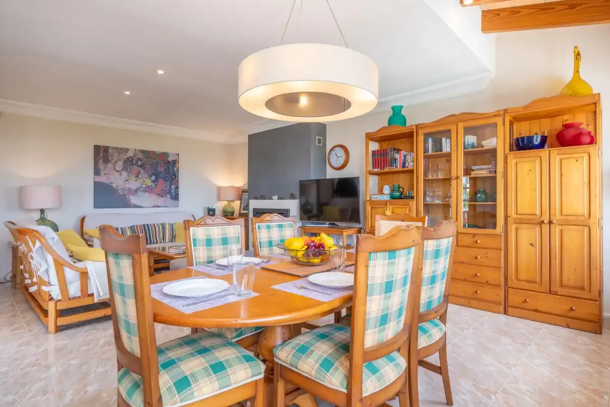 A dining and living room with a wooden table and seating.