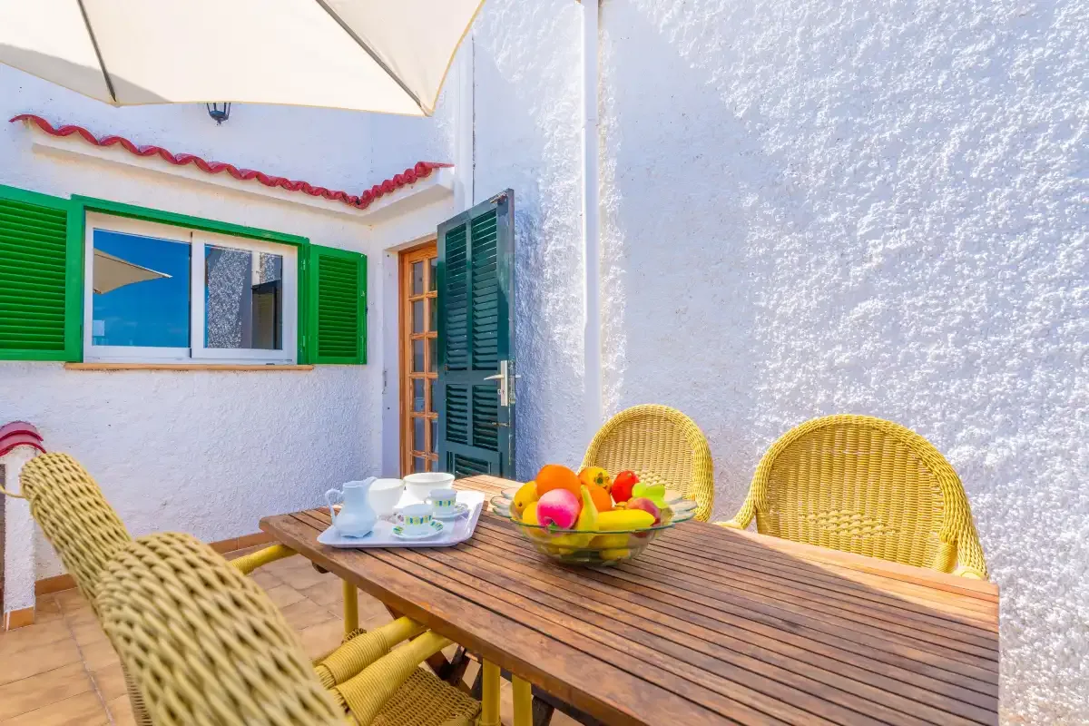 A patio dining area with a wooden table and woven seating.
