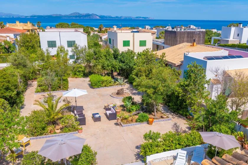 A landscaped courtyard with seating and a view of the sea beyond.