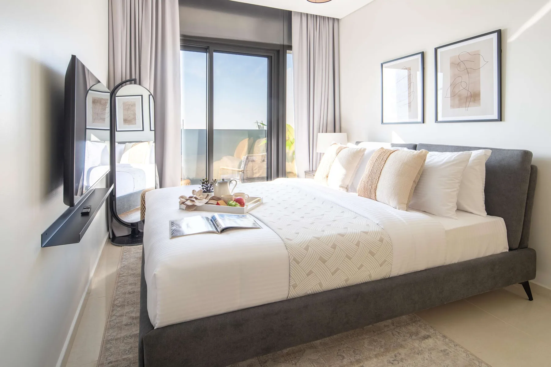 Un dormitorio luminoso con una cama bien tendida junto a una ventana amplia.