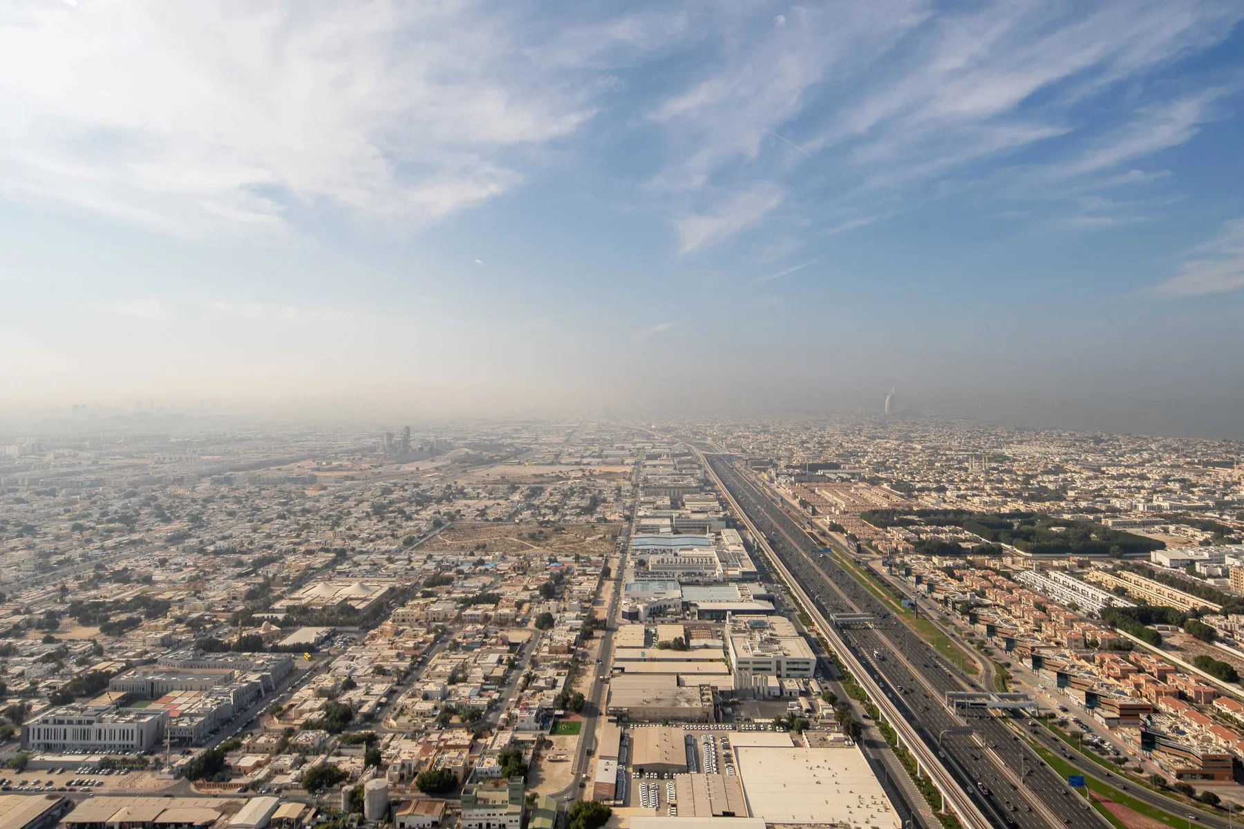 Vista aérea de la ciudad con edificios densos y una autopista que se extiende hacia el horizonte.