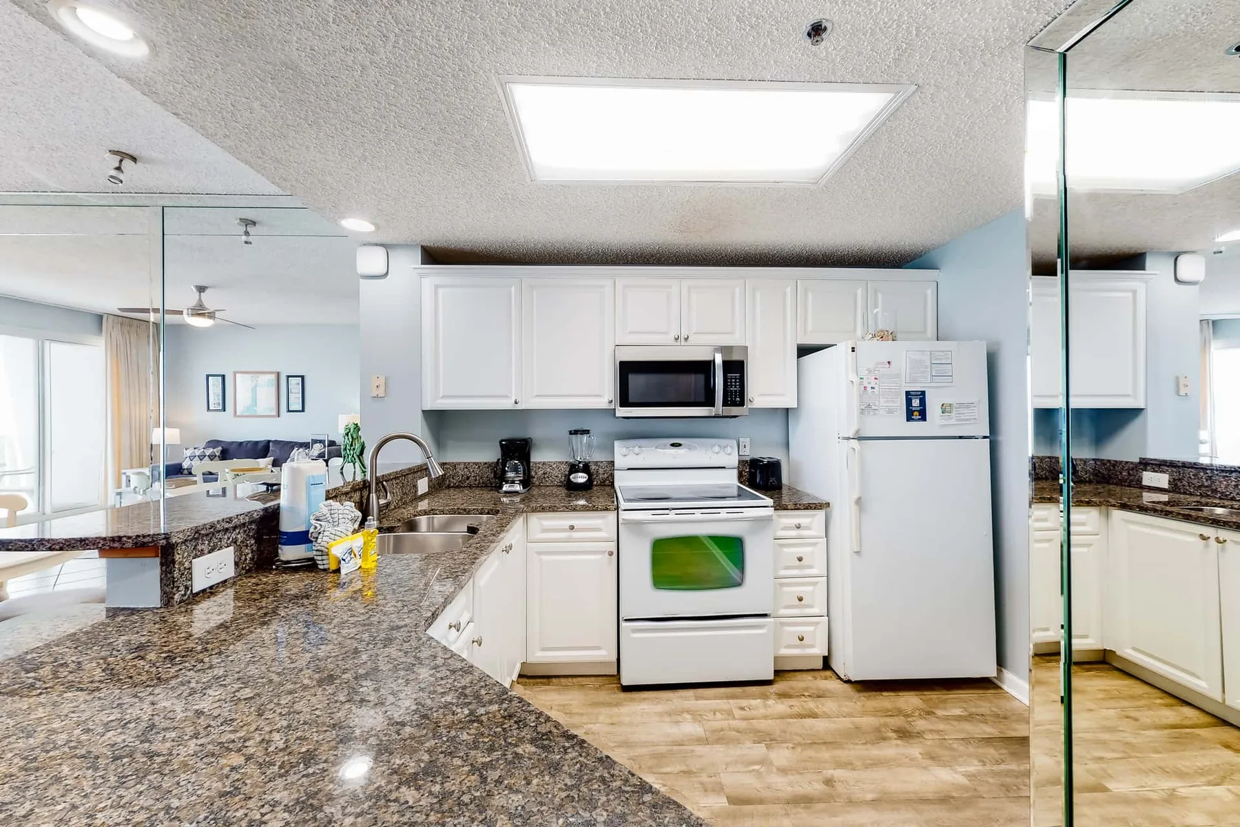 A bright kitchen with white cabinets, a stove, and a refrigerator.