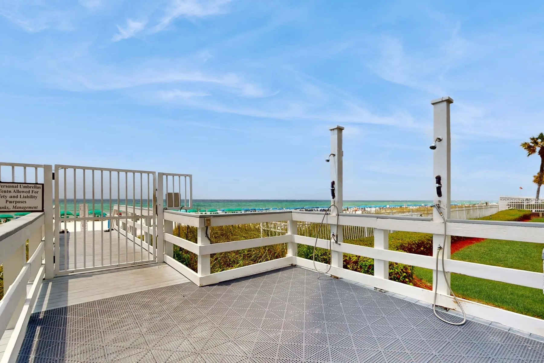 A seaside deck with white railings overlooks the ocean.