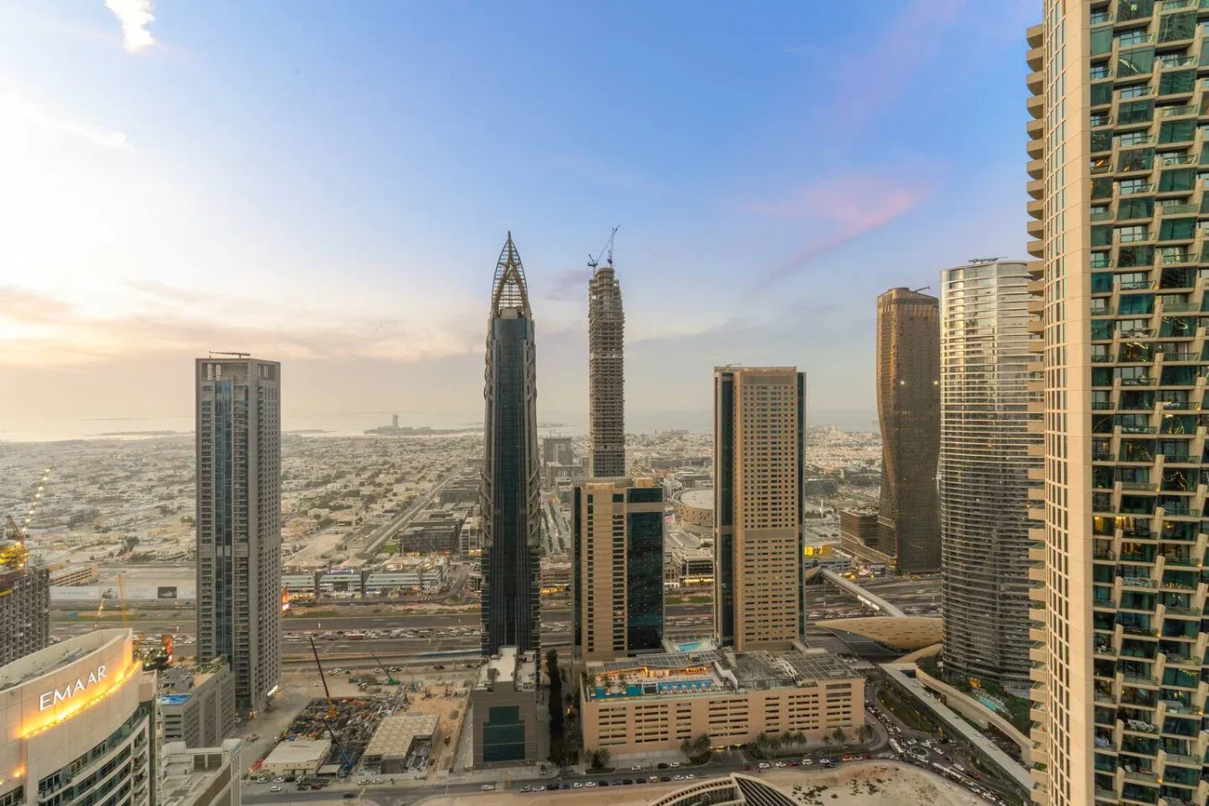 A city skyline with high-rise buildings beneath a clear evening sky.