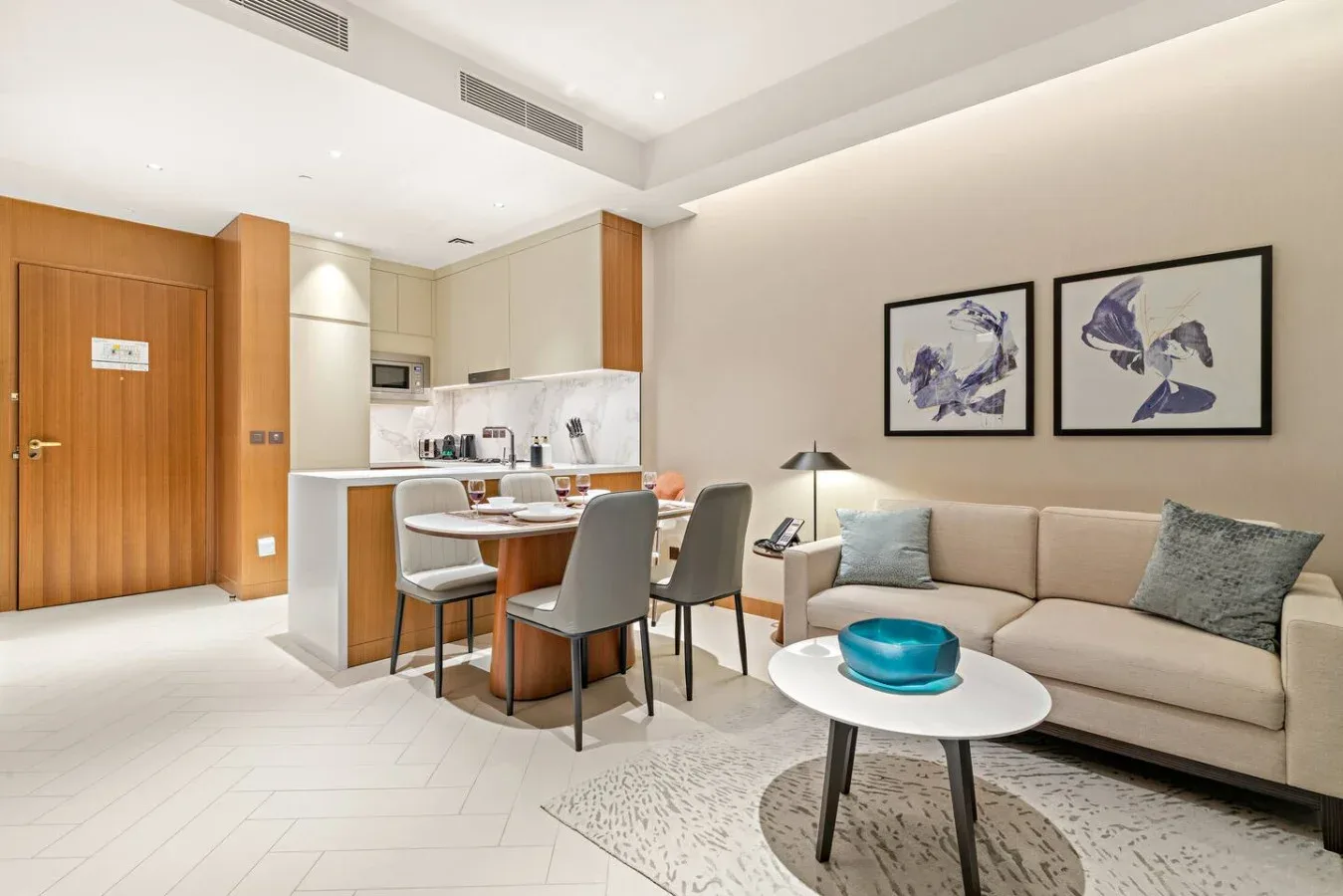 A bright living and dining area with a sectional sofa and compact kitchen.